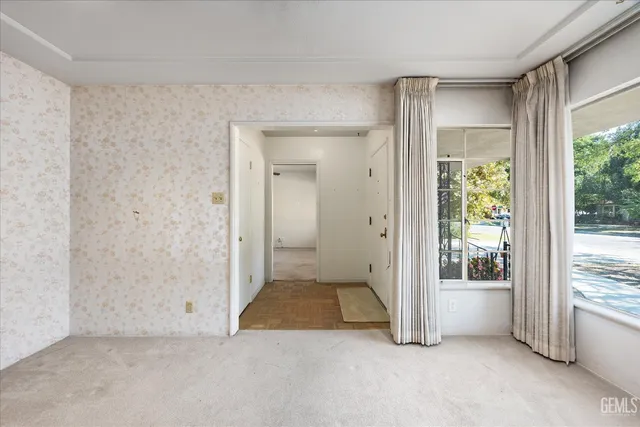 a view of a livingroom with a chandelier curtains and large windows