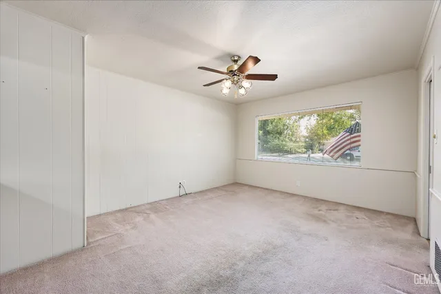 an empty room with fan and windows