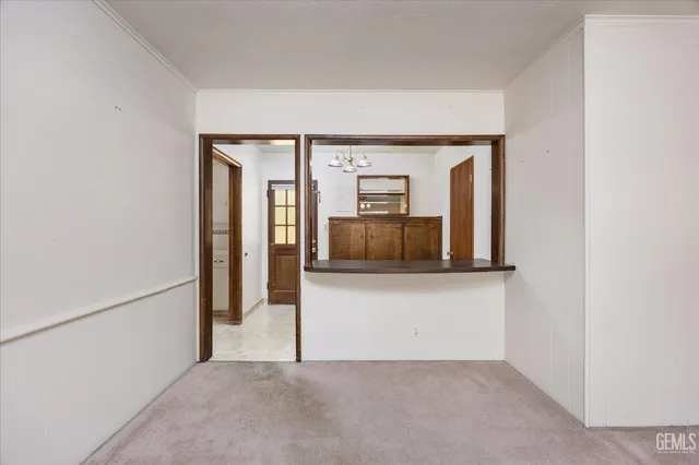 an empty room with chandelier fan and windows