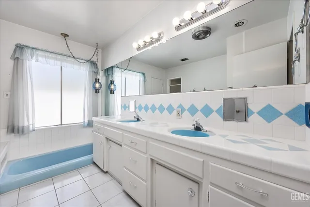 an empty room with a chandelier fan and windows