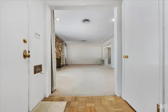 an empty room with floor to ceiling window and an outdoor view