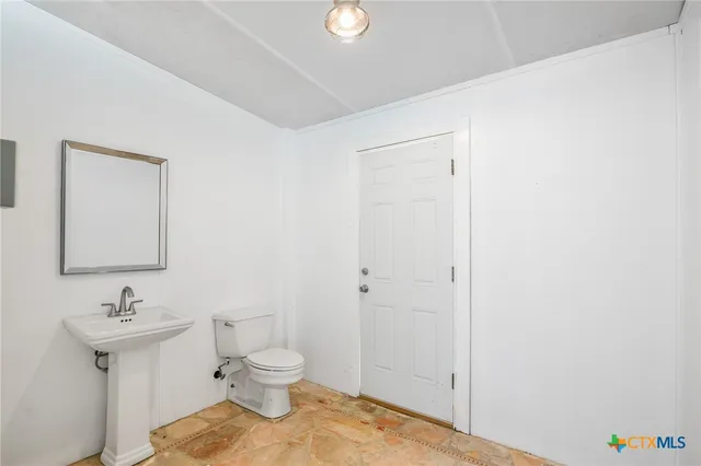 a bathroom with a sink toilet and a mirror