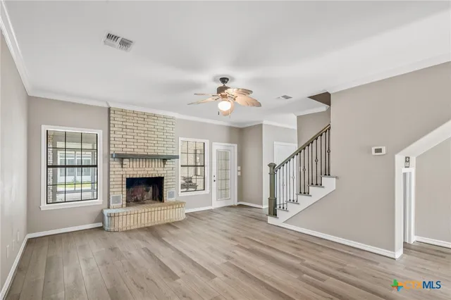 a view of an empty room fire place and a window