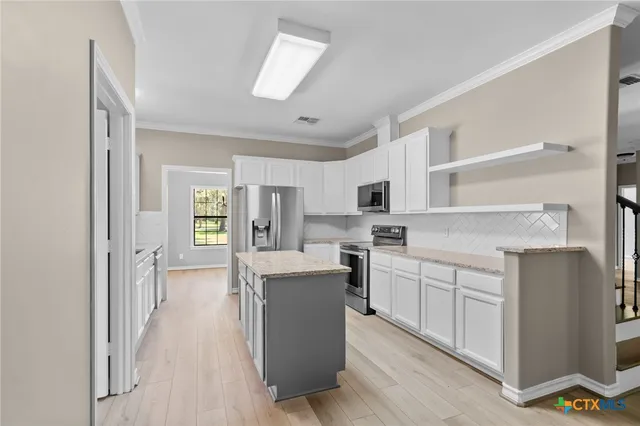 a kitchen with white cabinets and sink
