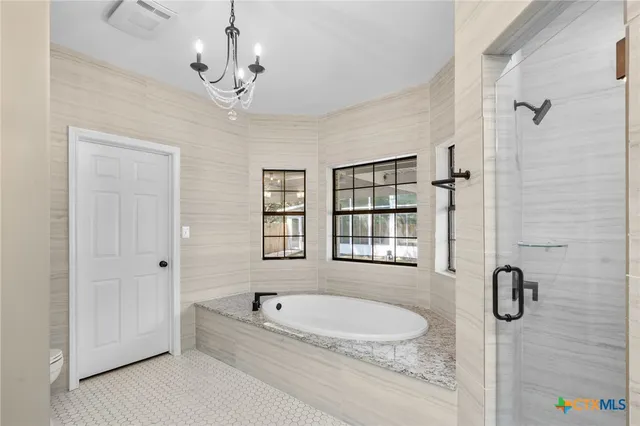 a bathroom with a granite countertop tub a sink and mirror