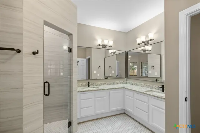a bathroom with a granite countertop sink mirror and shower