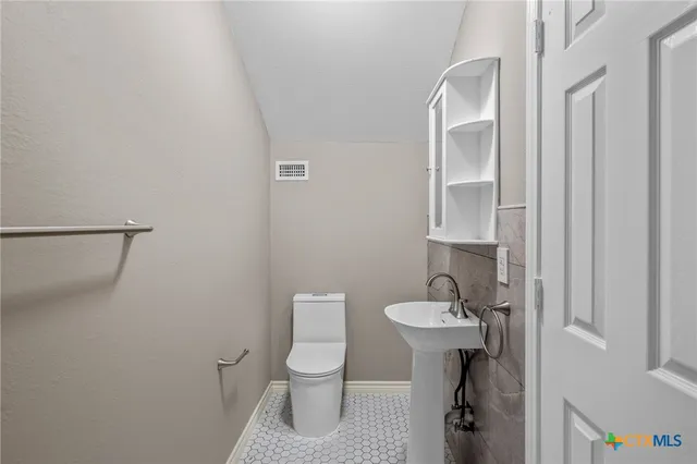 a bathroom with a toilet a sink and mirror