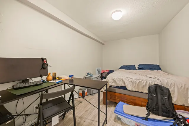 a bedroom with a bed and a computer on a table