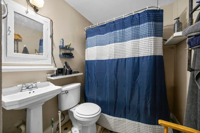 a bathroom with a sink a toilet and mirror