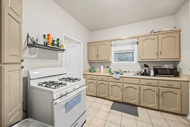 a kitchen with white cabinets and appliances