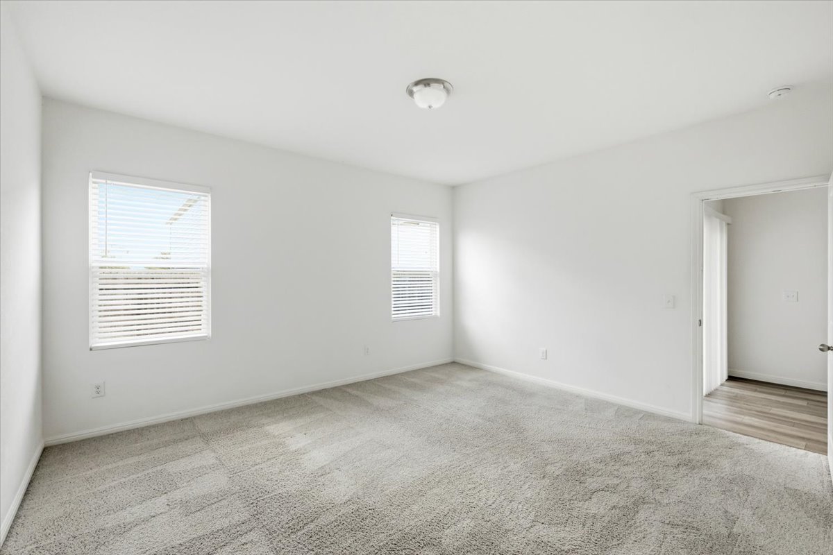 202 Peridot Pass Maxwell, TX 78656 - Photo 12 of 21 A spacious, naturally illuminated room featuring plush carpet and dual windows.