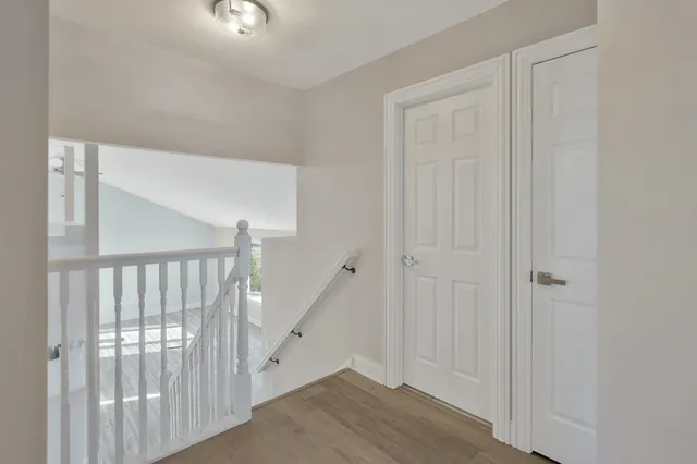 a view of a hallway with entryway with wooden floor