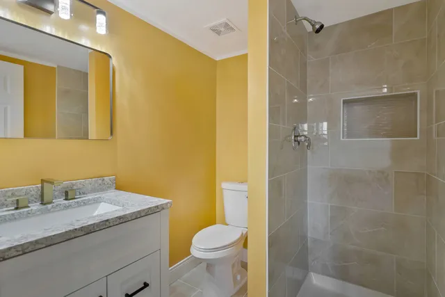 a bathroom with a granite countertop sink toilet and shower