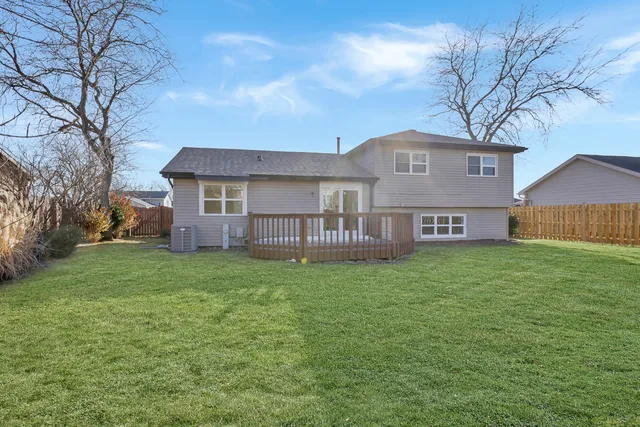 a view of a house with a big yard plants and large tree