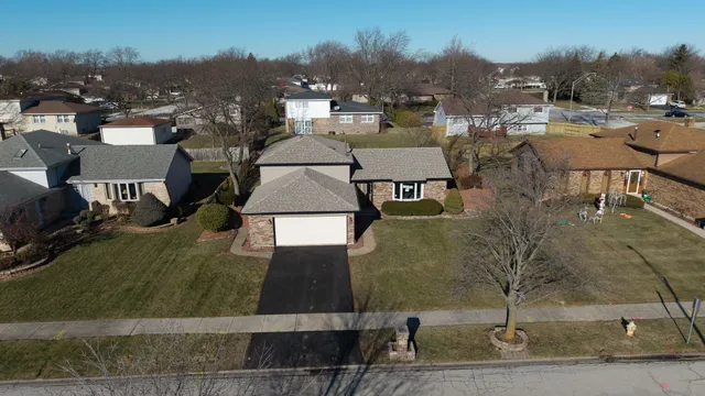 an aerial view of residential houses with outdoor space and parking