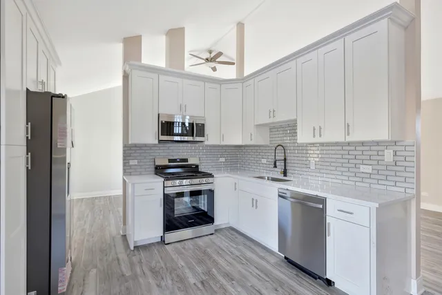 a kitchen with stainless steel appliances granite countertop a sink stove and refrigerator