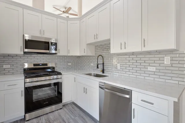 a kitchen with cabinets stainless steel appliances a sink and a microwave