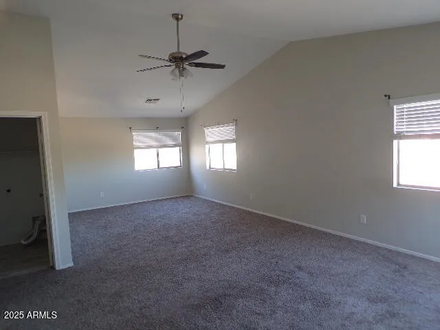 a view of a big room with windows and chandelier fan