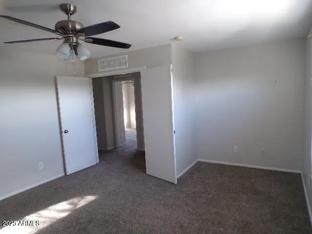 an empty room with a ceiling fan and a window