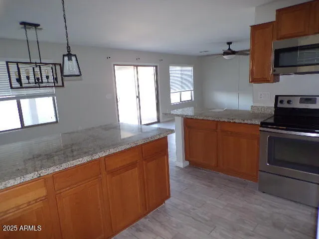 a kitchen with stainless steel appliances granite countertop a stove a sink and a microwave