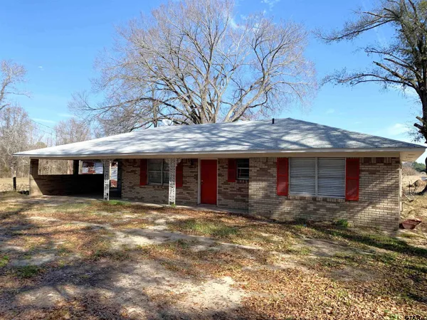 a view of a house with a yard and large tree