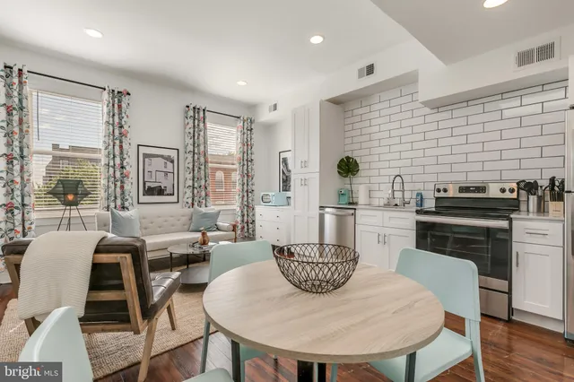 a kitchen with a table chairs and refrigerator