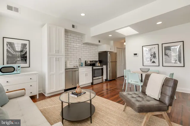 a living room with furniture and kitchen view