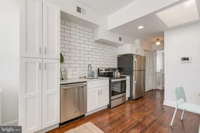 a kitchen with a sink cabinets and wooden floor