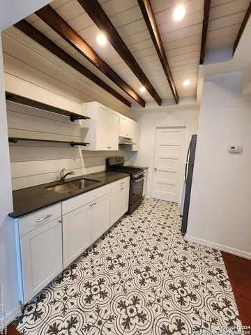 a kitchen with granite countertop a sink and cabinets