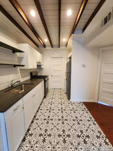 a large kitchen with a sink and cabinets
