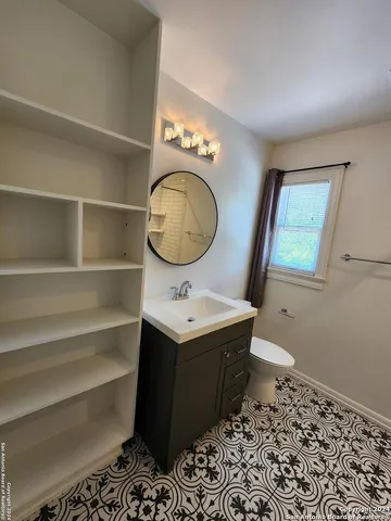 a bathroom with a sink toilet and a mirror