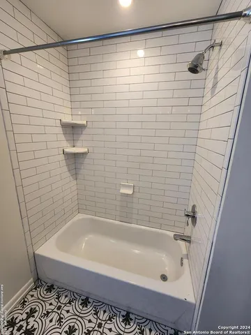 a bathroom with a bathtub and shower