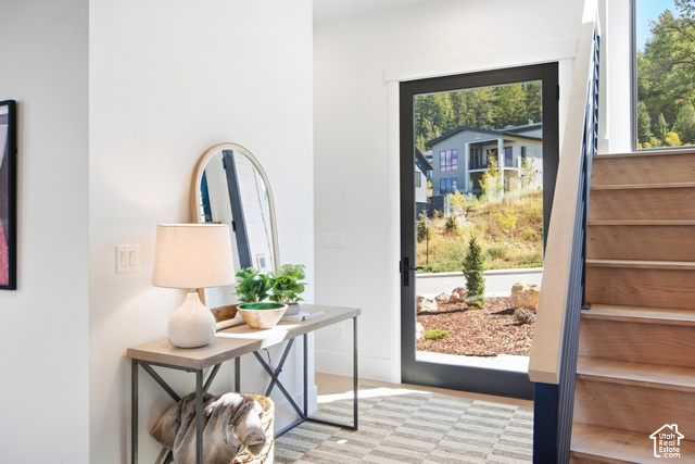 4092 Discovery Way Park City, UT 84098 - Photo 4 of 66 Black-framed glass entry door, wood-finish staircase with dark balusters, white wall finishes, and a neutral patterned area rug