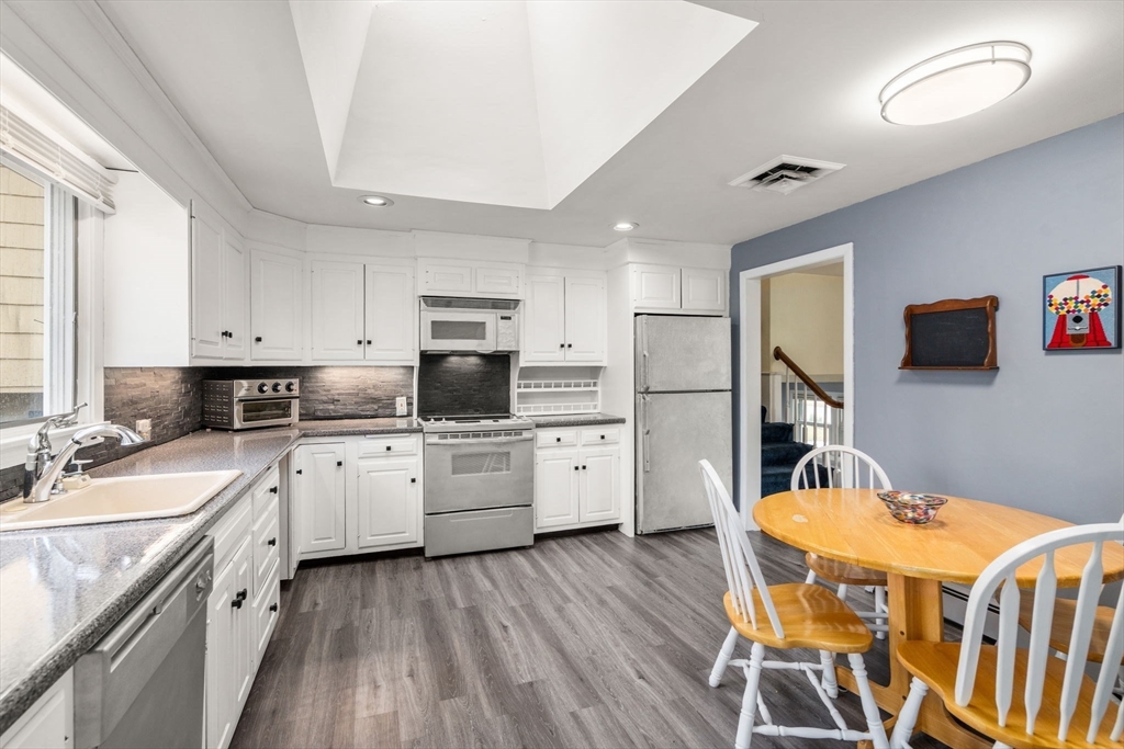 48 Gary Road Needham, MA 02494 - Photo 12 of 20 a kitchen with stainless steel appliances sink refrigerator dining table and chairs