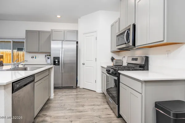a kitchen with stainless steel appliances granite countertop a refrigerator stove and sink