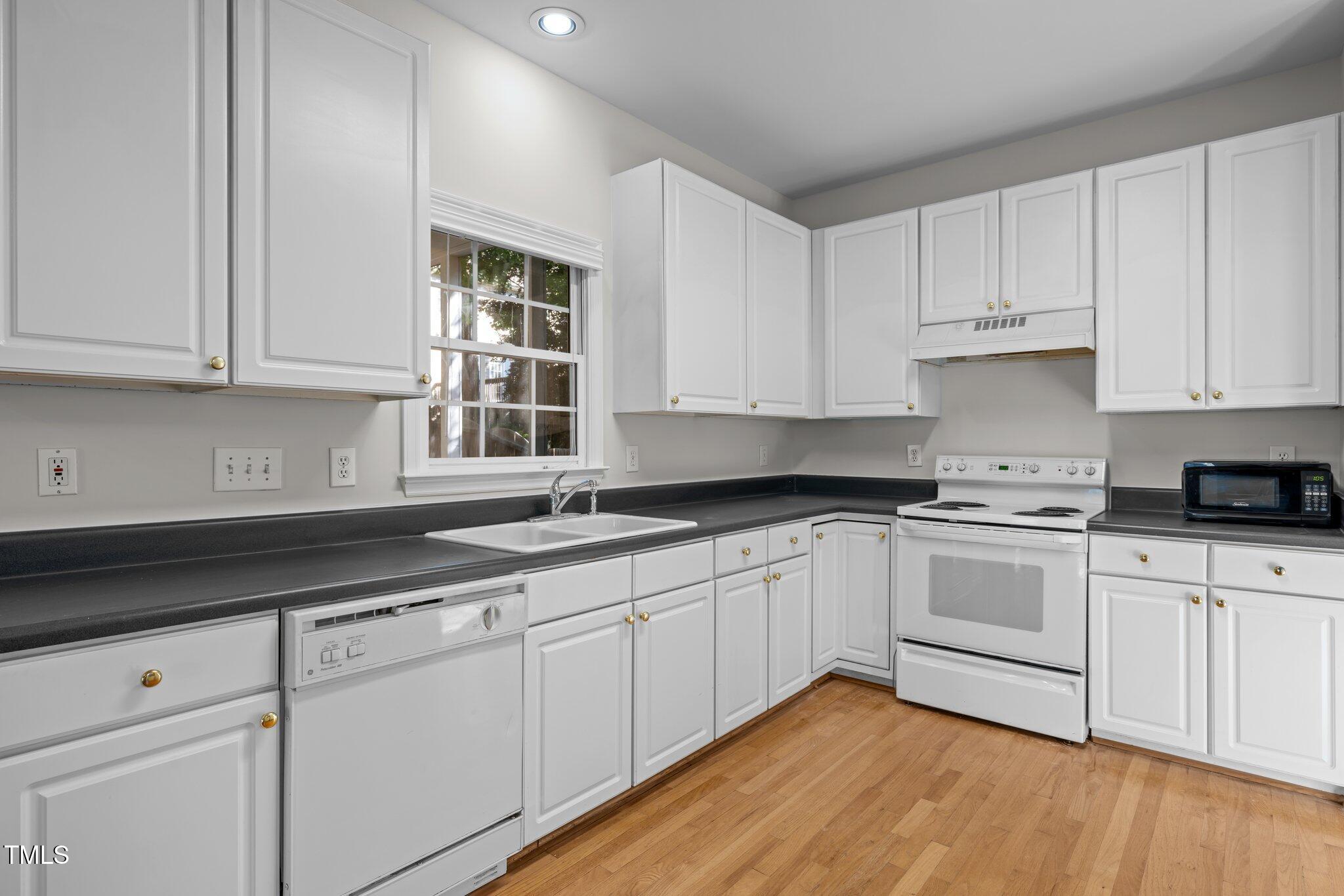 2309 Clerestory Place Raleigh, NC 27615 - Photo 13 of 37 a kitchen with granite countertop white cabinets and white appliances