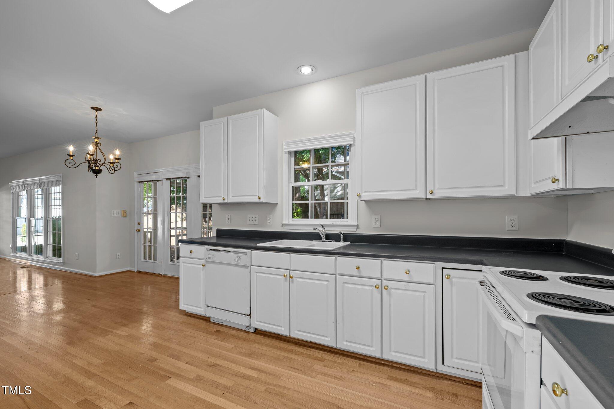 2309 Clerestory Place Raleigh, NC 27615 - Photo 15 of 37 a kitchen with granite countertop white cabinets and a stove