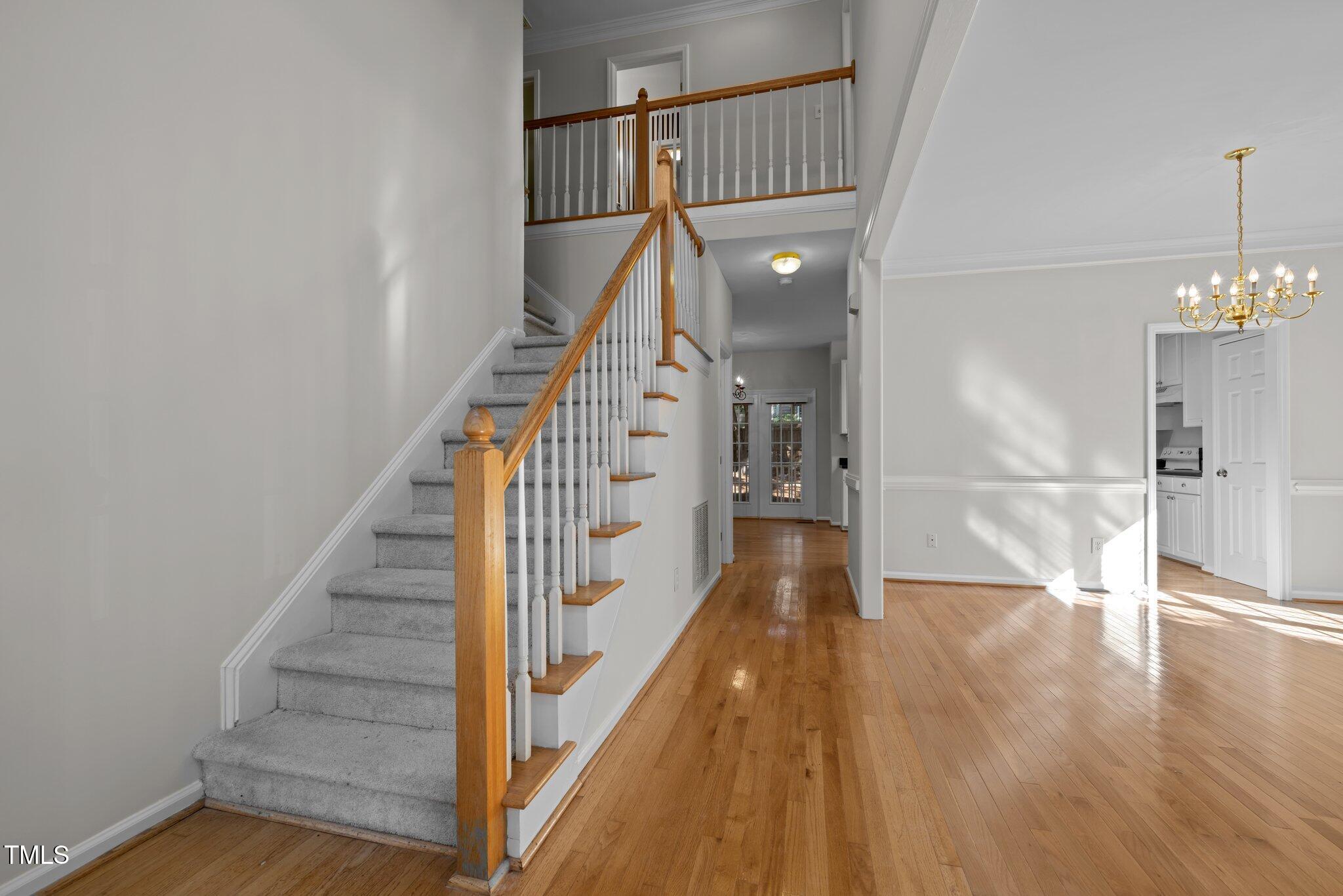 2309 Clerestory Place Raleigh, NC 27615 - Photo 7 of 37 a view of a hallway with wooden floor and staircase