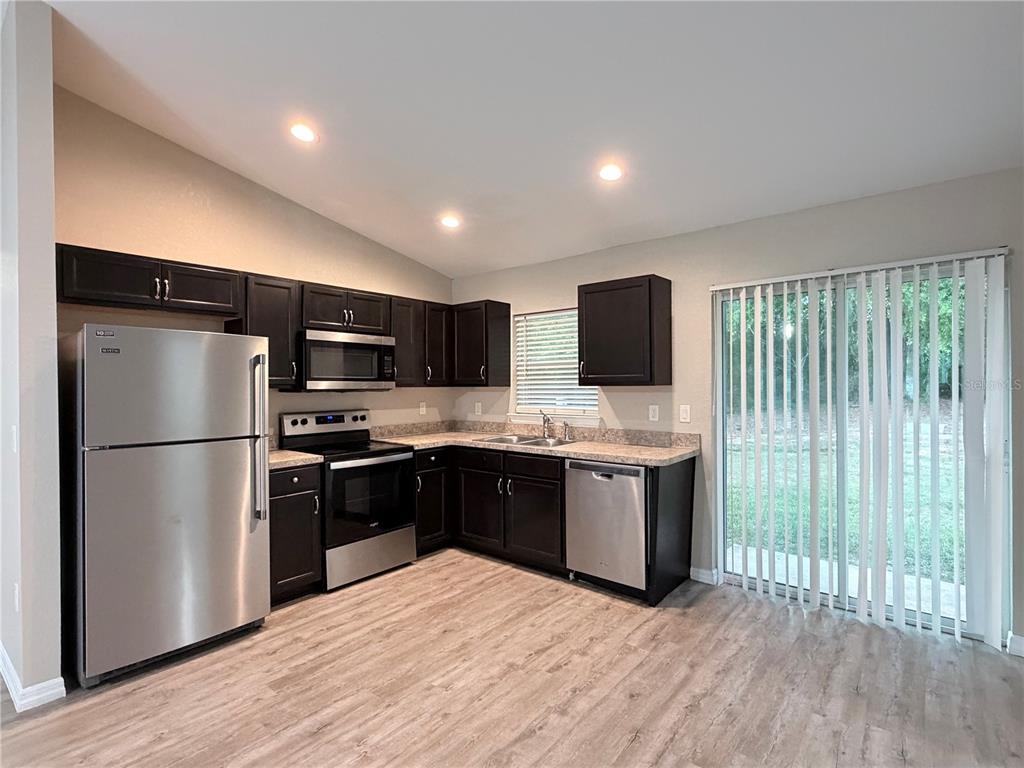 14445 Southwest 22nd Place Ocala, FL 34481 - Photo 4 of 11 a large kitchen with a large window and stainless steel appliances