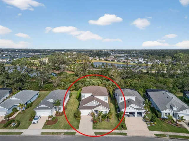 a front view of a house with a yard and mountain view in back