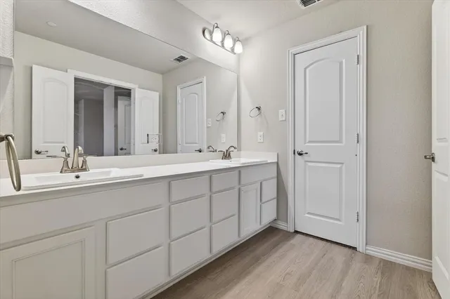 a bathroom with a double vanity sink and mirror