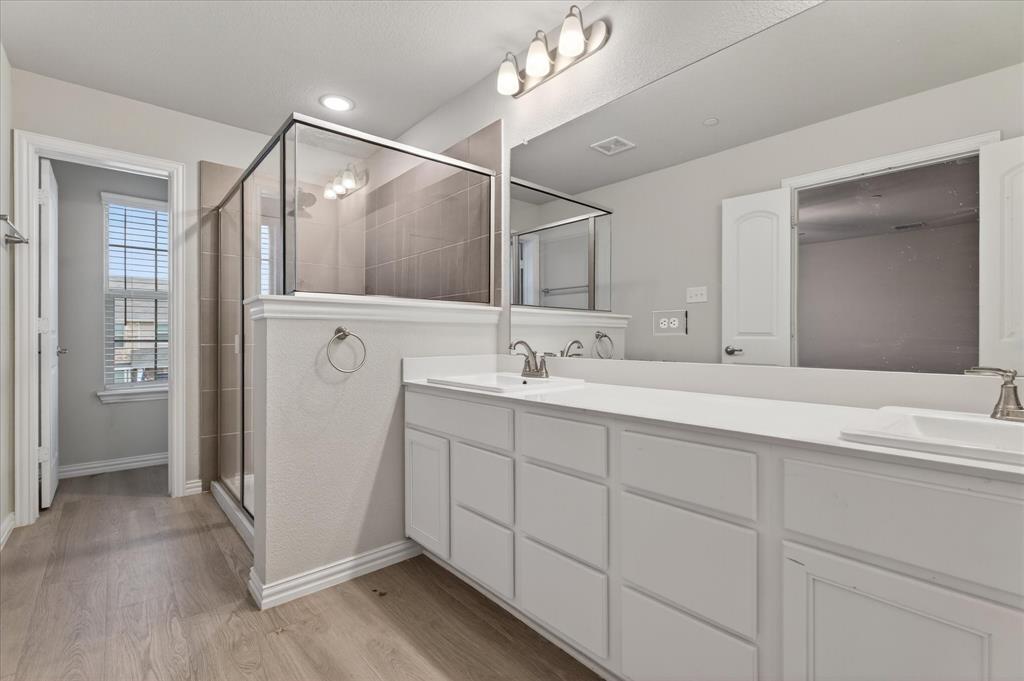 2200 Davenport Drive Denton, TX 76207 - Photo 17 of 23 a bathroom with a double vanity sink a mirror and a shower