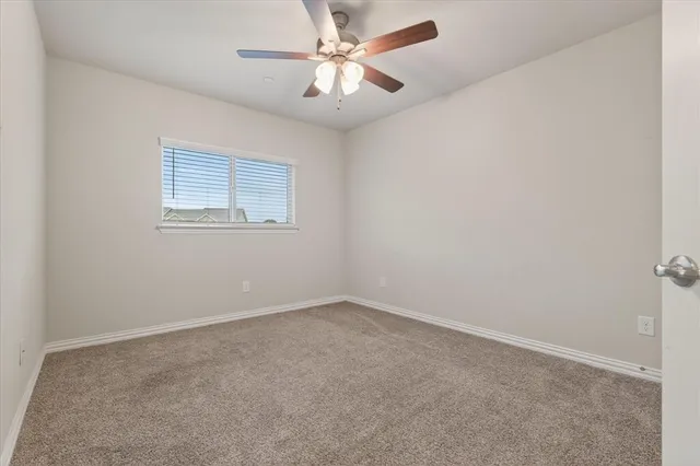 an empty room with a window and a fan
