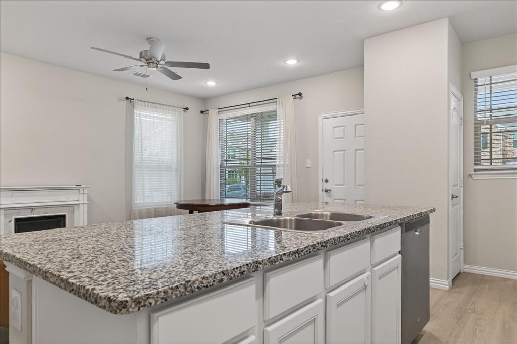 2200 Davenport Drive Denton, TX 76207 - Photo 8 of 23 a kitchen with center island a sink cabinets and wooden floor