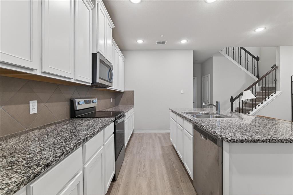2200 Davenport Drive Denton, TX 76207 - Photo 9 of 23 a kitchen with stainless steel appliances granite countertop a sink and a granite counter tops
