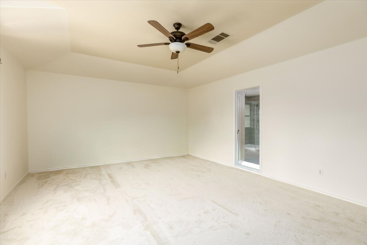 7136 Ridge Oak Road Austin, TX 78749 - Photo 29 of 40 A spacious primary bedroom features soft carpet and a ceiling fan for comfort.