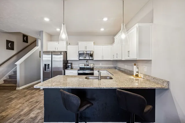 a kitchen with stainless steel appliances granite countertop a sink a stove a refrigerator and island