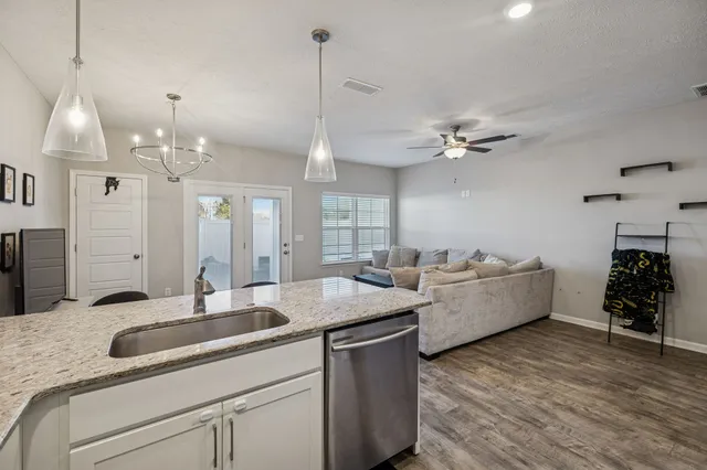 a kitchen island with granite countertop a sink dishwasher a fireplace with wooden floor