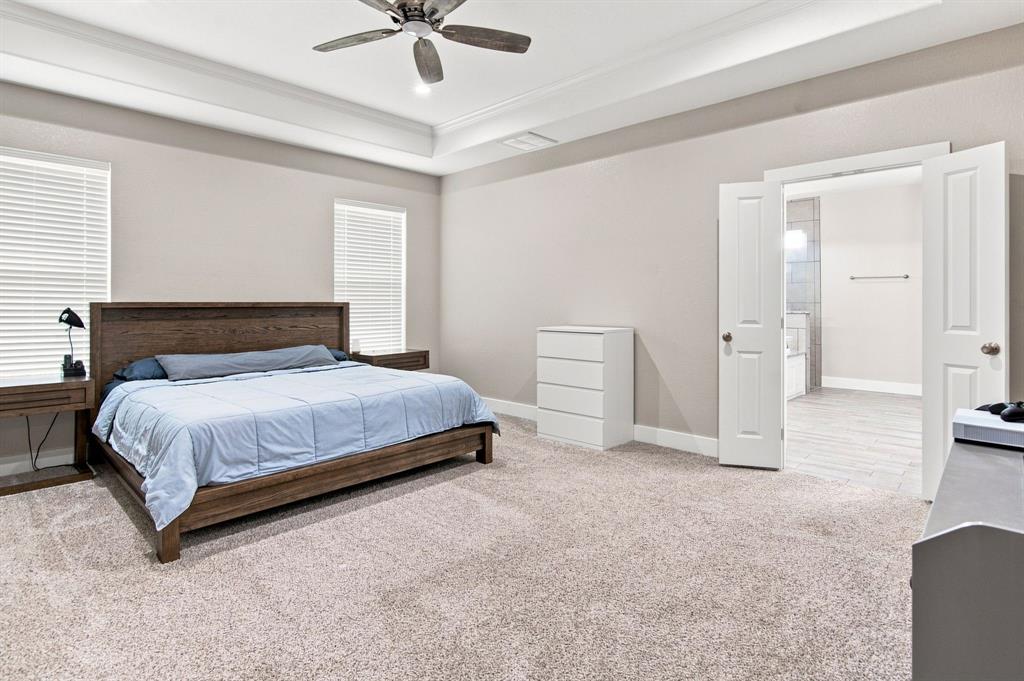 121 Friendship Way Boyd, TX 76023 - Photo 20 of 38 Spacious room featuring neutral carpeting, tray ceiling with a ceiling fan, dual windows with blinds, and white trim throughout
