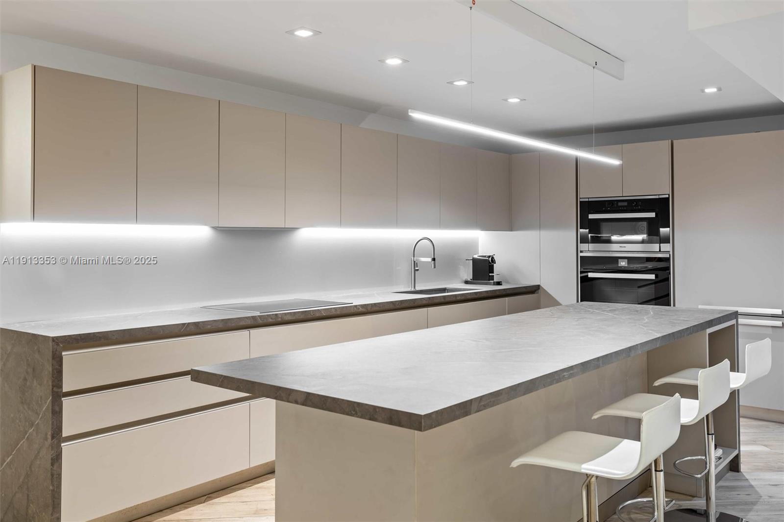 2301 Collins Avenue, Unit 1432 Miami Beach, FL 33139 - Photo 42 of 63 a kitchen with a table chairs microwave and cabinets